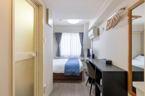 A hotel room with a bed, a desk, a chair, a TV, and a mirror. - Sleep Inn Gotanda (Tokyo)