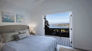 A bedroom with a bed, pillows, a nightstand, and a view of a balcony. - Coastal Charm - Oceanview Stay in Pacifica Near SF (Pacifica)
