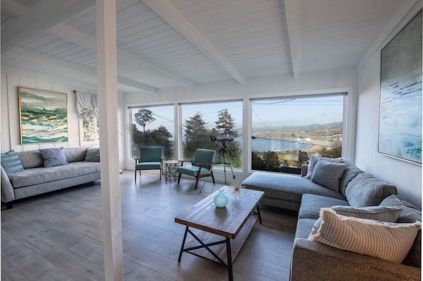 A modern living room with a sofa, a coffee table, and a view of the outdoors.