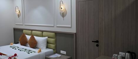 A modern hotel room with a bed, bedside tables, a desk, and a ceiling fan.