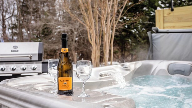 Un jacuzzi con una botella de RUFFINO Prosecco y una copa.