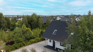 Un quartier résidentiel où les maisons sont entourées de verdure, avec une étendue d’eau en arrière-plan.