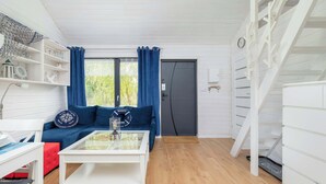 A modern living room with a white coffee table, blue sofa, and a staircase.