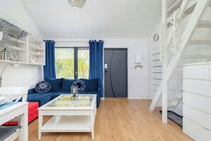 A modern living room with a white coffee table, blue sofa, and a staircase.