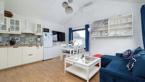 A compact living space with a kitchen, dining area, and a sofa.