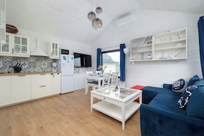 Ein kompakter Wohnraum mit Küche, Essbereich und einer Couch.