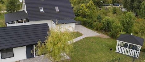 Et boligområde med moderne huse, en pavillon og en velholdt græsplæne.