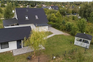 Ein Wohngebiet mit modernen Häusern, einem Pavillon und einem gepflegten Rasen.