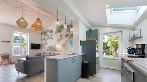 A modern kitchen with a central island, built-in appliances, and a large window providing natural light.