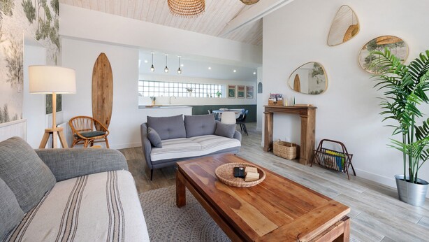 A living room with a sofa, a coffee table, a lamp, a chair, a fireplace, and wall art.