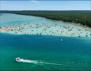 Vista aérea de una zona costera con numerosos barcos y una pequeña isla con densa vegetación.