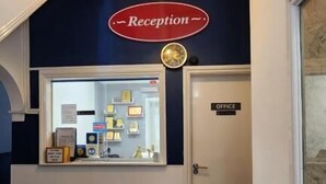 A reception area with a sign labeled "Reception," a display case with certificates, and a door marked "Office."