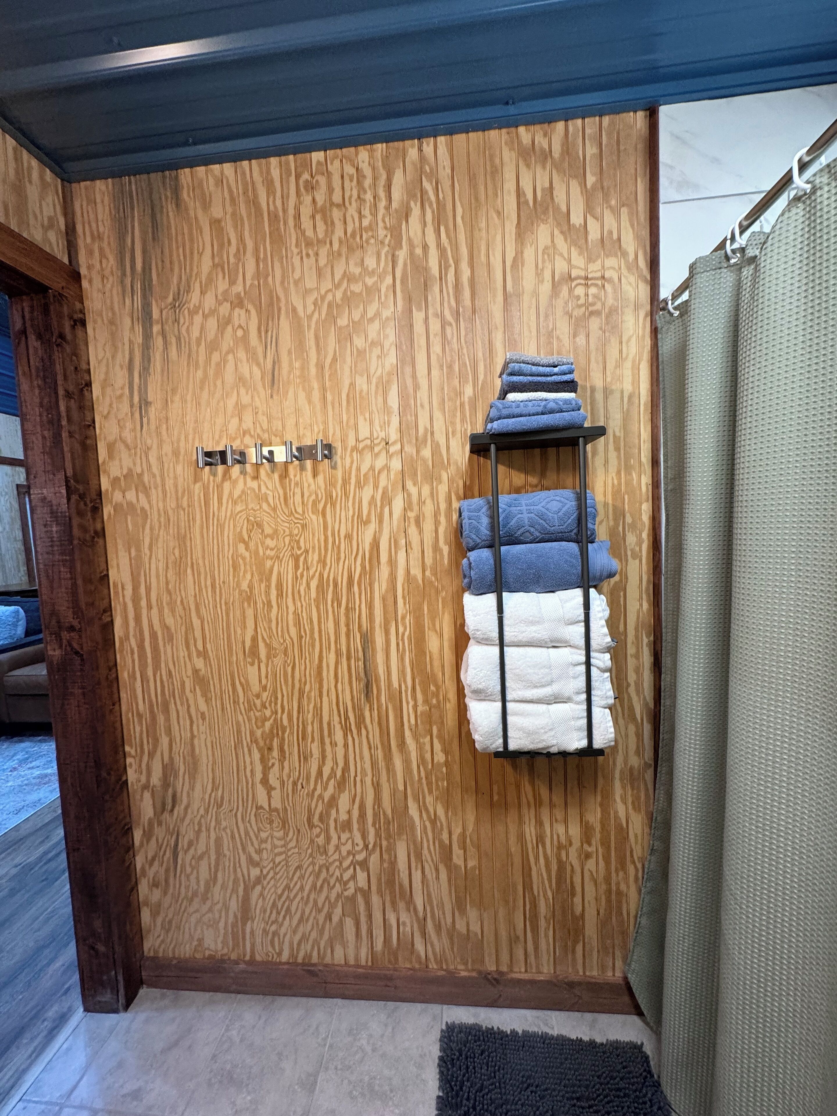 A wooden door with a towel rack holding folded towels.