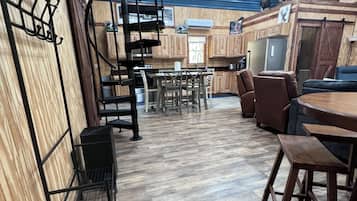 A spacious kitchen with wooden cabinets, a dining area with a table and chairs, and a spiral staircase.