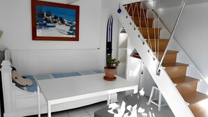 A modern interior with a white bench, a potted plant, a staircase, and a framed picture on the wall. - Villa Esterel, for 14 people, located 200 m from the beach (La Faute sur Mer)