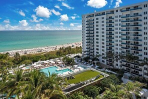 Un hotel con piscina, vistas a la playa y un edificio de gran altura.