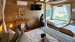 Ein gemütliches Schlafzimmer mit einem großen Bett, einem Schreibtisch und einem Fenster mit Vorhängen.