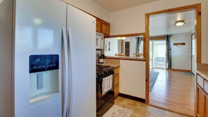 Una cocina con refrigerador, estufa, microondas y gabinetes de madera.