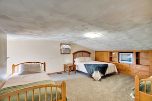Ein Schlafzimmer mit zwei Holzbett, einem Fernseher und einem Holzschrank.
