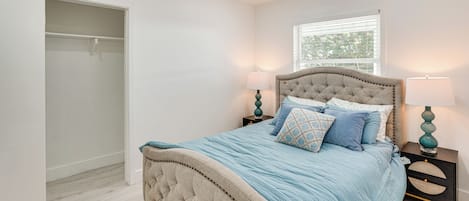 A bedroom with a bed, nightstands, a window, and a closet.