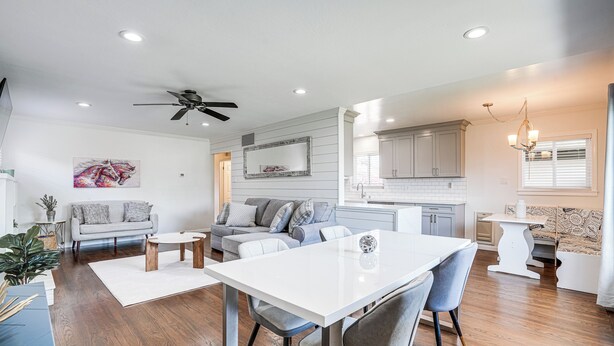 Un salon moderne comprenant un coin repas, une cuisine et un ventilateur de plafond.