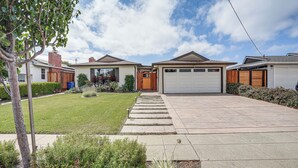 Il s’agit d’une propriété résidentielle dotée d’une allée pavée, d’un portail en bois et d’un garage.