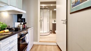 Una cucina moderna con piano cottura integrato, una macchina da caffè e una pianta sul ripiano.