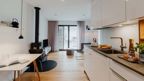 A modern kitchen with a central island, a dining area with a table and chairs, and a cozy seating area with a sofa.