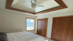 A bedroom with a bed, wooden wardrobe, and a ceiling fan. - Lovely 3-bedroom condo with AC in De Pere, WI. 10 min drive from Lambeau field. (De Pere)