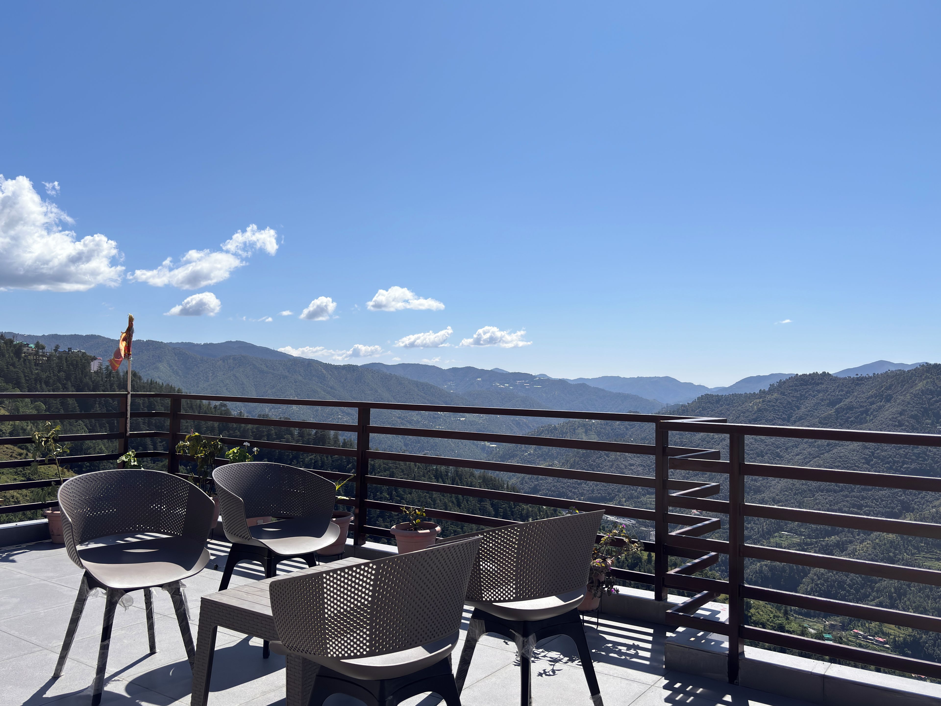 Una terraza con mobiliario exterior y vistas a un paisaje montañoso.