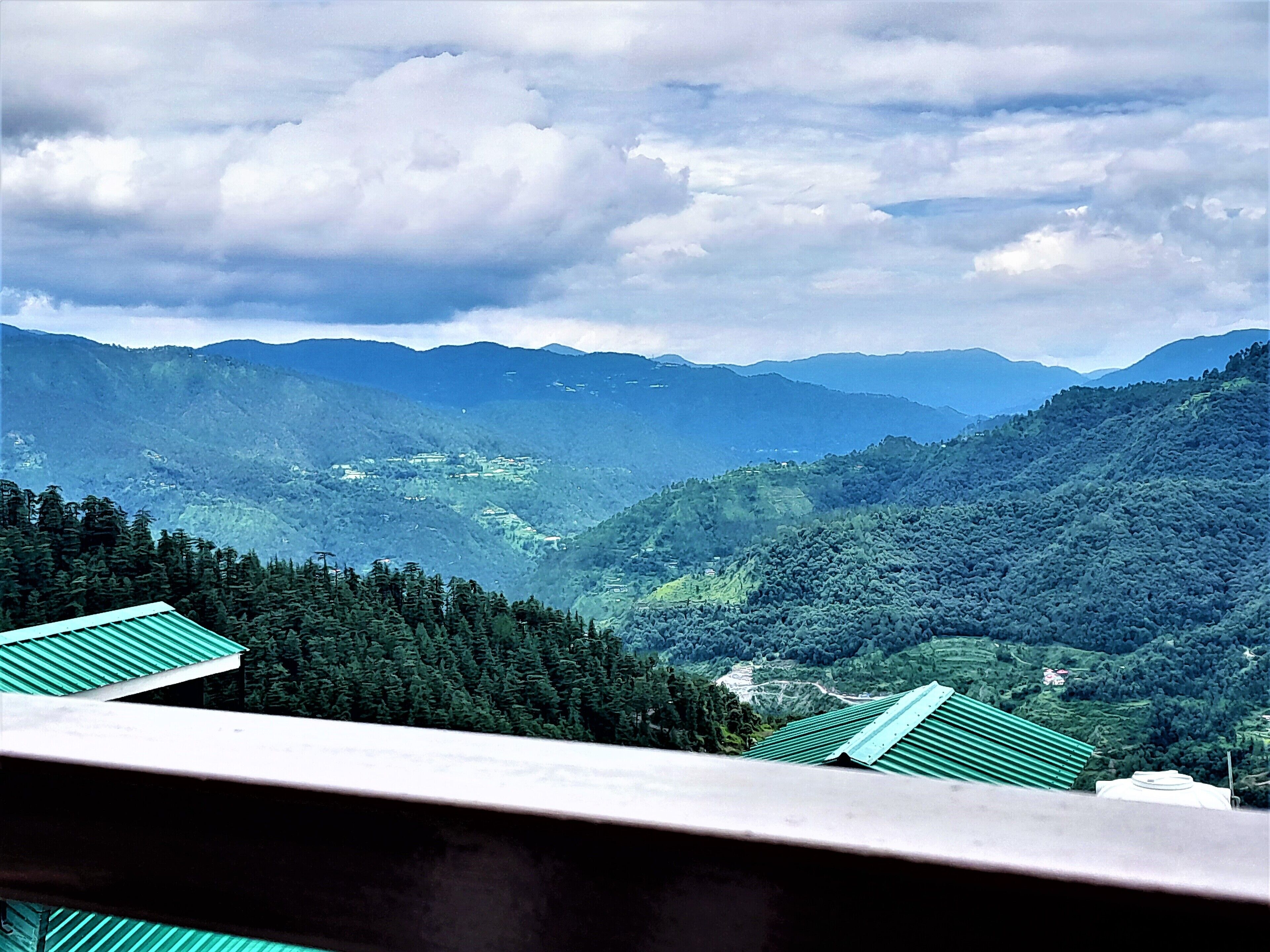 Un paisaje montañoso con vistas a un valle y montañas distantes.