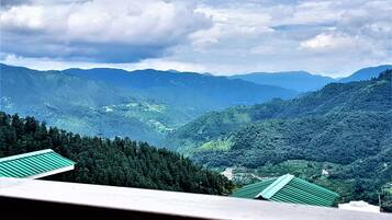 Un paisaje montañoso con vistas a un valle y montañas distantes.