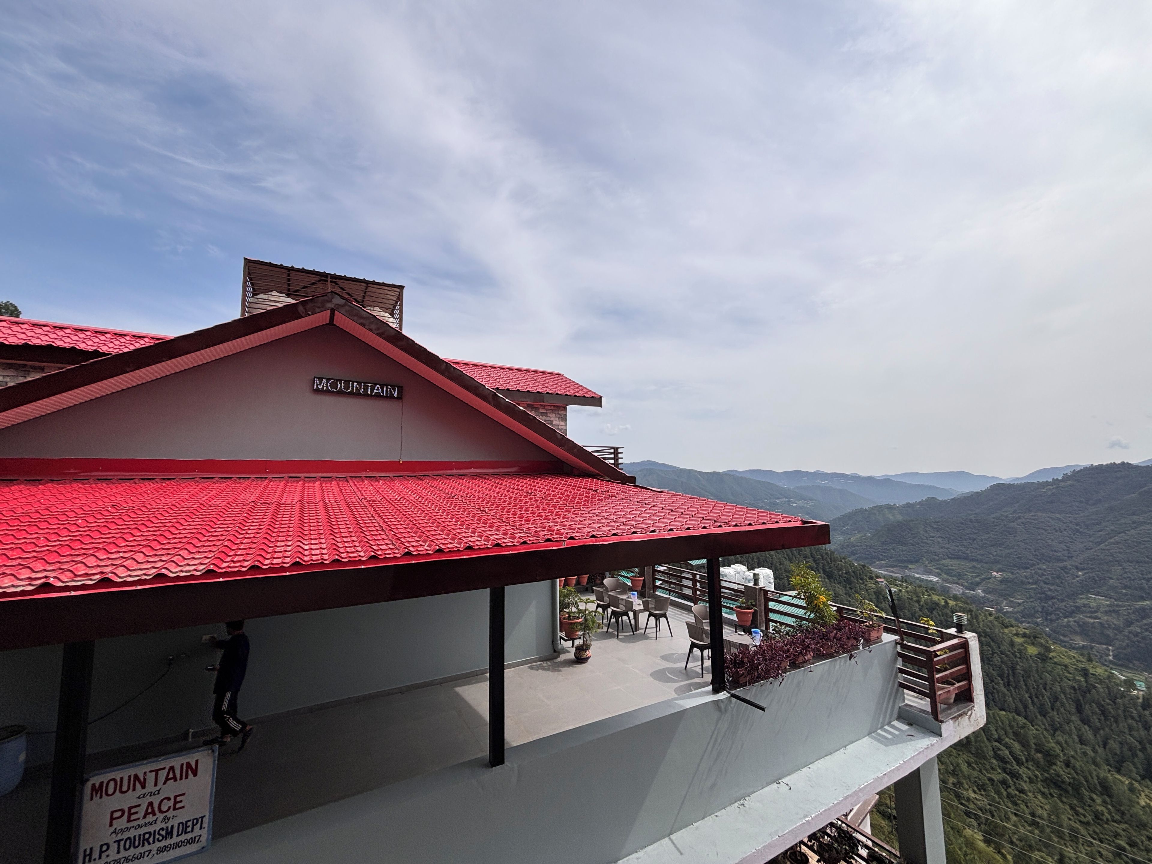 Un edificio con techo rojo y un letrero que dice 'MOUNTAIN PEACE'.