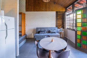 Una cocina moderna con un refrigerador blanco, un sofá azul y una mesa de comedor con sillas.