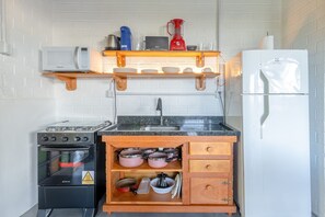 Casa Signature | Cocina privada | Frigorífico, microondas, utensilios de cocina y mesa de comedor