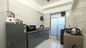 A modern kitchen with a built-in refrigerator, a microwave, and a coffee maker. - Studio Apartment ( Kitchen ) (Mumbai)