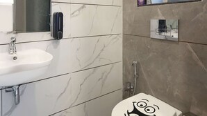 A modern bathroom with a toilet, sink, and mirror. - Studio Apartment ( Kitchen ) (Mumbai)