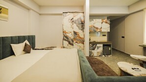 A modern hotel room with a large bed, a desk, and a bathroom.