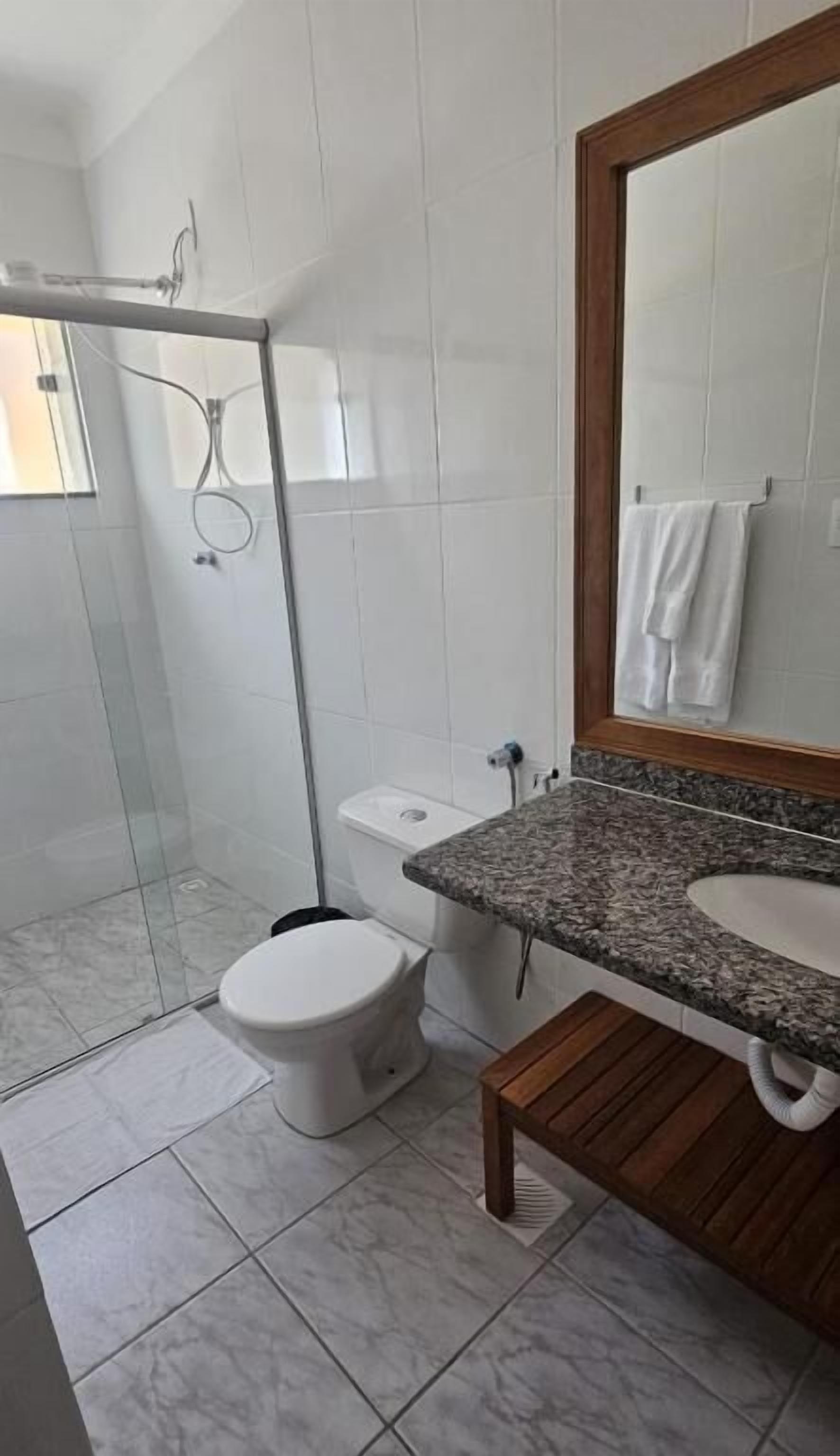 Ein Badezimmer mit Dusche, Toilette und Waschbecken.