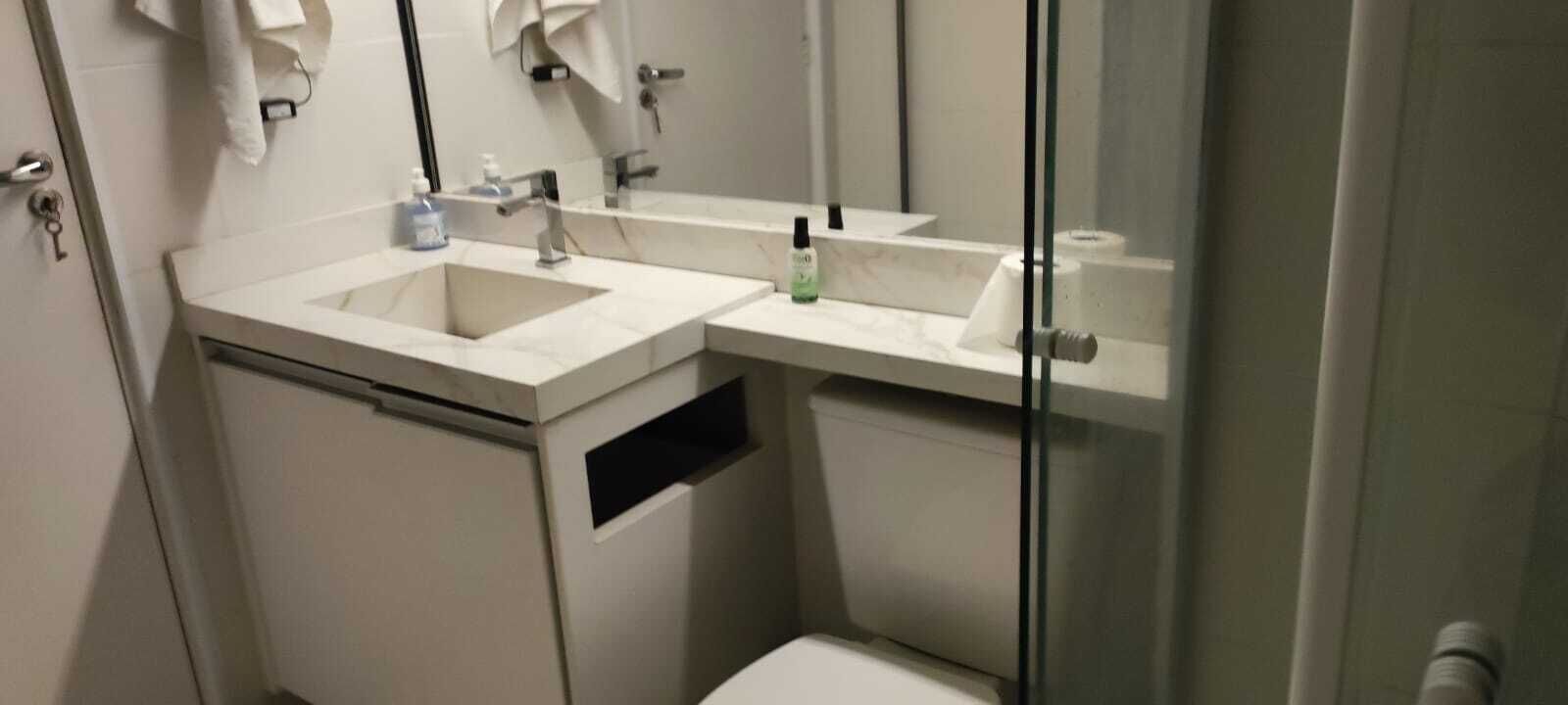 Ein Badezimmer mit zwei Waschbecken, einer Toilette und einer Duschkabine aus Glas.