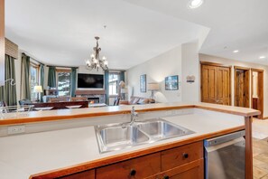 Una cocina amplia con una isla grande, armarios de madera y lavavajillas integrado.