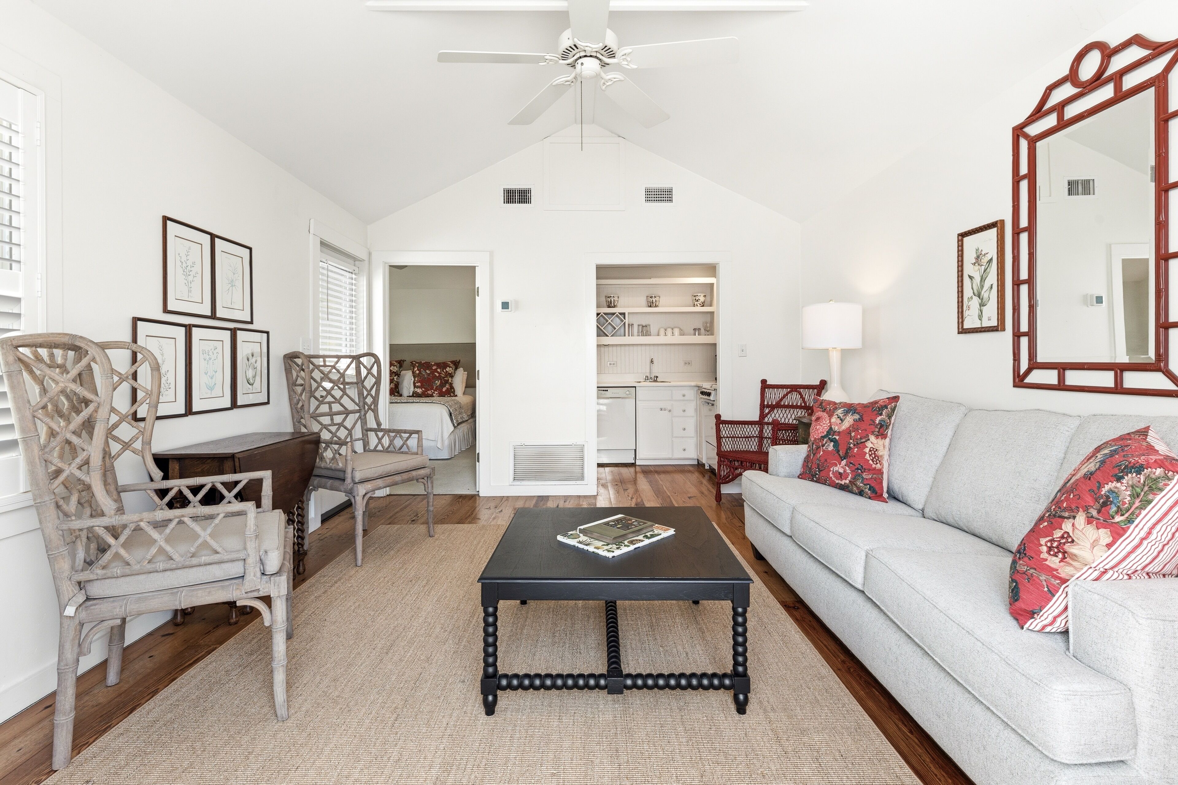 A living room with a sofa, a coffee table, and a dining area with chairs.