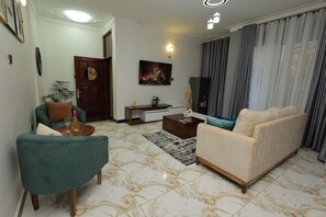Comfort Apartment, City View | Living area | 58-inch Smart TV with cable channels - The Nest Kampala (Kampala)
