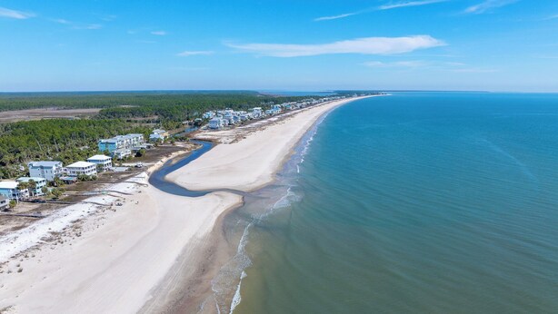 An aerial view of a coastal area with a long sandy beach, a river running parallel to the shore, and a row of buildings along the beach. - ☀️Short, 3 Min Walk to Beach | Gulf Views | Papa's Palmetto Place☀️ (Indian Pass)