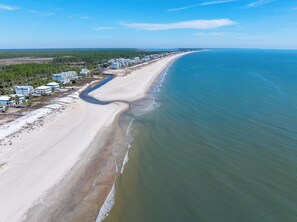 An aerial view of a coastal area with a long sandy beach, a river running parallel to the shore, and a row of buildings along the beach. - ☀️Short, 3 Min Walk to Beach | Gulf Views | Papa's Palmetto Place☀️ (Indian Pass)