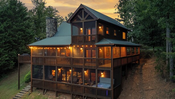 A two-story log cabin with a balcony and large windows, surrounded by trees. - Forever View- Mountain View Cabin (Blue Ridge)
