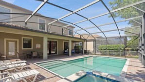Une piscine extérieure couverte, dotée de chaises longues, d ’un jacuzzi et d’un espace patio avec tables et chaises.