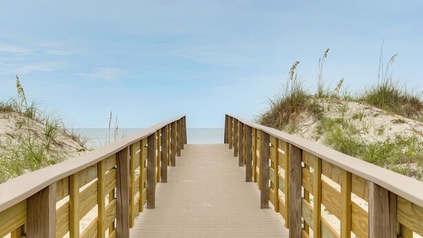 A wooden boardwalk leading to the beach with sandy dunes and grass on either side. - Cape San Blas Gem w/ Sunrise + Sunset Views (Port St Joe)
