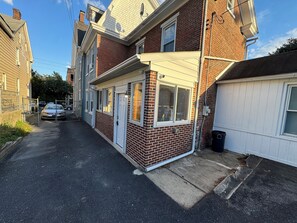 A residential street with houses, a parked car, and a clear sky.