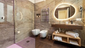 A modern bathroom with a glass-enclosed shower, a marble-tiled wall, a vanity with a mirror, and a bidet. - 69 Suite Boutique (Rome)